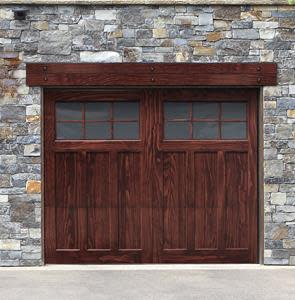 A brown wooden garage door with four small, square windows at the top and a stone wall surrounding it. A horizontal beam runs above the door, blending seamlessly with the rustic and sturdy exterior design.